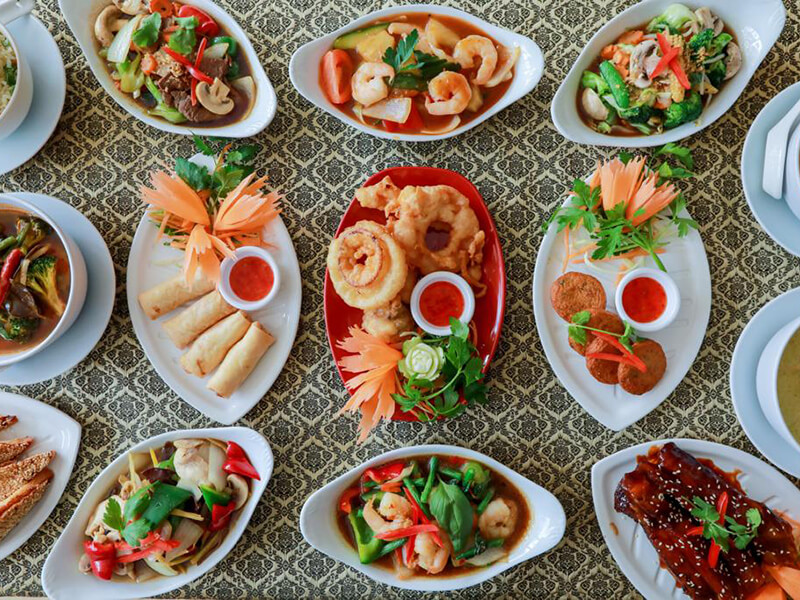 A spread of Mai Thai dishes, including prawns, spring rolls and vegetable dishes
